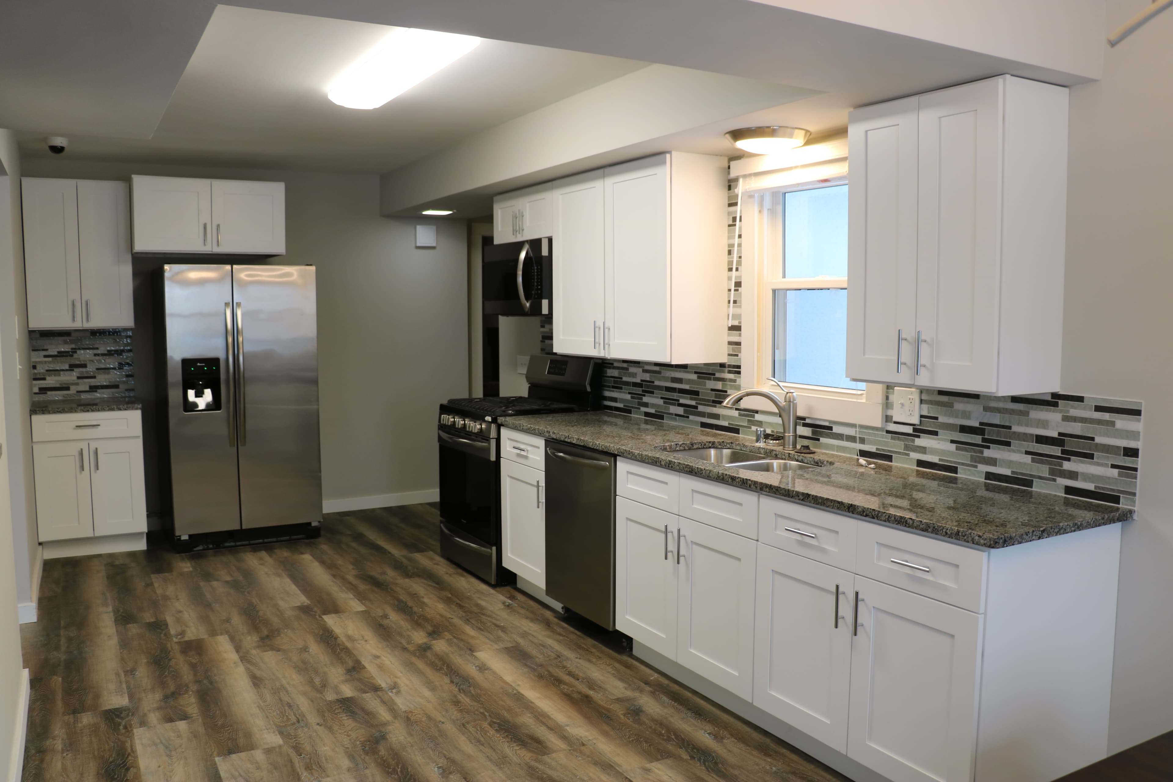 Modern kitchen with white cabinets, stainless steel appliances, and accessible counter space