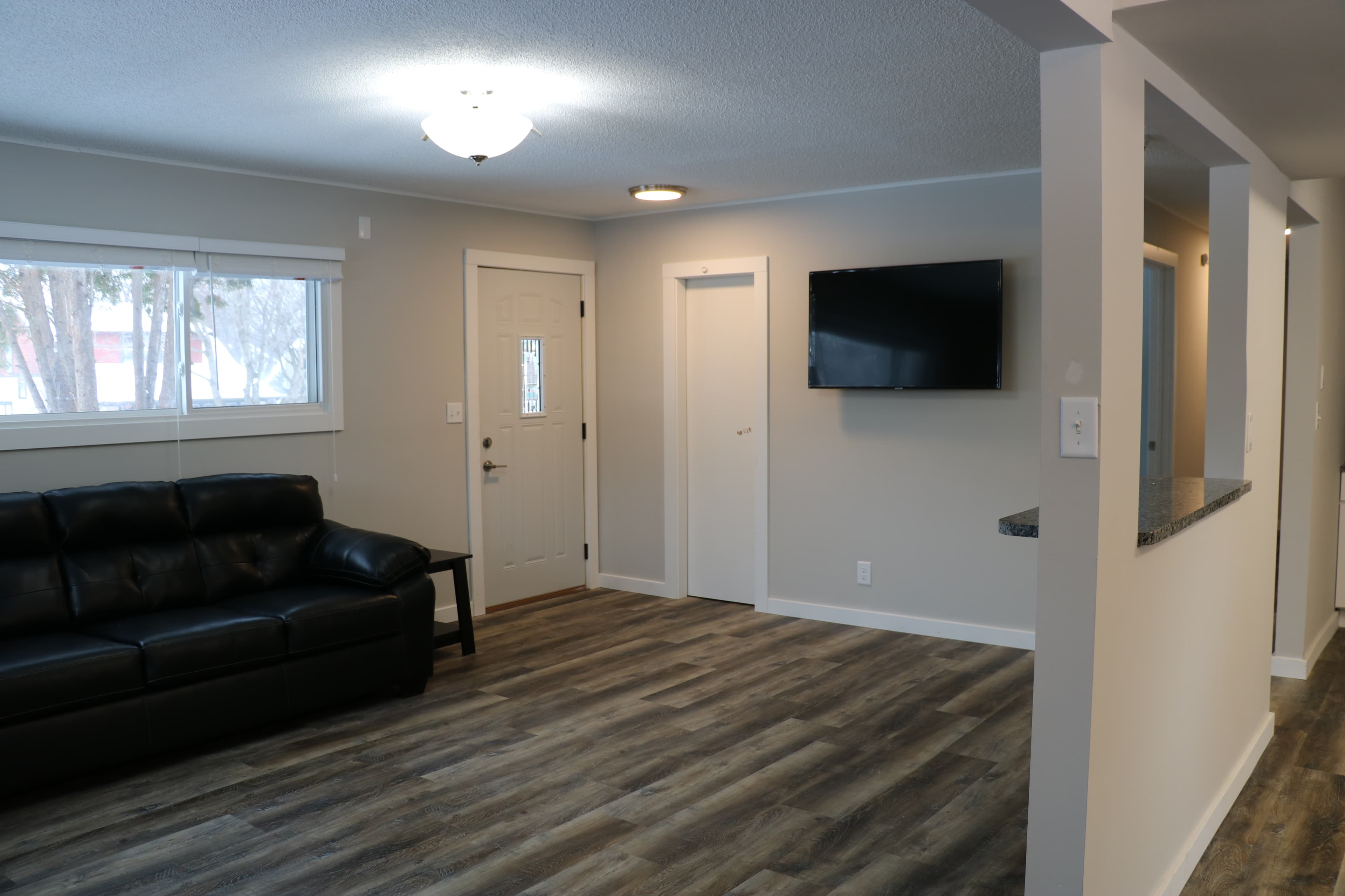 Comfortable living room with seating, natural light, and a wall-mounted television